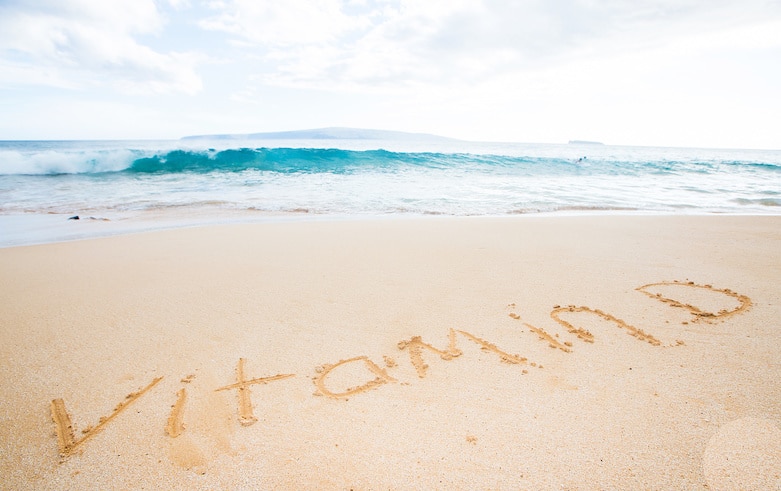 Vitamin D written in the sand at a tropical beach