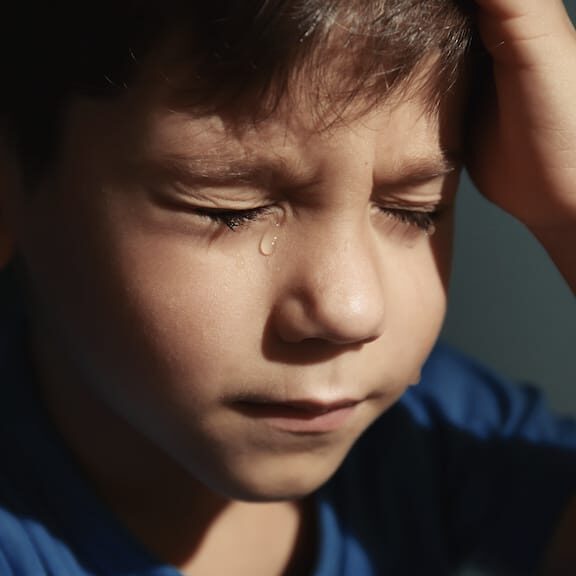 Little sad boy crying. Abuse of children concept